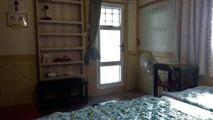 白河Joel's Garden 悠爾庭園古厝民宿的一间卧室配有一张床、一个窗口和一张书桌