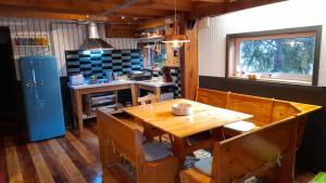 马拉卡韦罗Mapunre的厨房配有木桌、椅子和冰箱。
