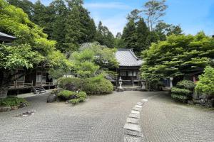 高野山高野山 宿坊 宝城院 -Koyasan Shukubo Hojoin-的一座带房子和鹅卵石街道的花园
