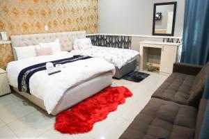 约翰内斯堡Gold Crown International Hotel的一间卧室配有一张大床和红色地毯。