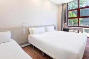 富恩拉夫拉达B&B HOTEL Madrid Fuenlabrada的一间白色卧室,配有两张床和窗户