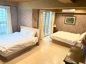 台南二姐的家的酒店客房设有两张床和窗户。