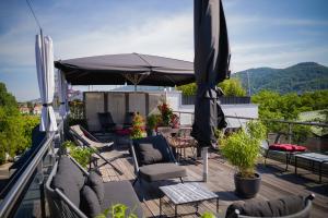 海德堡Qube Hotel Bergheim的露台配有椅子和遮阳伞,位于甲板上