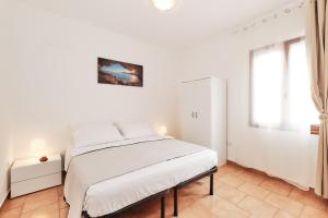 马蒂诺Casa Mazzini的白色的卧室设有床和窗户