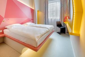 明斯特prizeotel Münster-City的色彩缤纷的客房里设有一间卧室和一张床