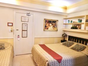 悉尼查林顿酒店的一间卧室配有一张床,一扇门配有绘画作品