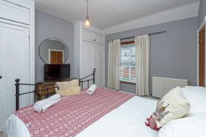 里辛Beautiful Redbrick Home in Ruthin Centre & Parking的一间卧室配有一张大床和镜子