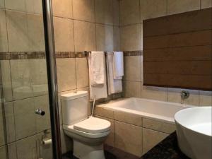 约翰内斯堡59 on Central的浴室配有卫生间、浴缸和水槽。