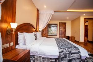 坎帕拉Kalanoga Resort的一间卧室配有一张大床和木制床头板