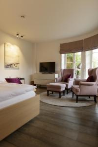 凯图姆Hotel Aarnhoog的一间卧室配有一张床、两把椅子和一台电视