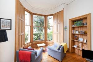爱丁堡ALTIDO 3-bed Meadows flat near Castle的客厅配有两把椅子和大窗户