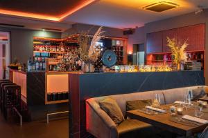 海德堡Qube Hotel Bergheim的一间带2张桌子的餐厅和一间酒吧
