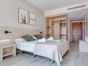 巴塞罗那limehome Barcelona Carrer de Besalú 82的一间卧室设有两张床,铺有木地板