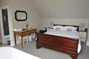 滨海绍森德苏恩诺斯旅馆的一间卧室配有一张床、一张书桌和一面镜子