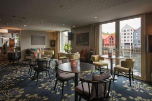 特隆赫姆巴克兰迪斯堪迪克酒店的餐厅设有桌椅和大窗户。