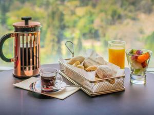 圣地亚哥Pullman Santiago Vitacura的一张桌子,上面放着两篮面包和一杯咖啡