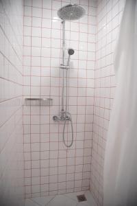 芭堤雅市中心Tali-Yailai Hostel的白色瓷砖浴室内的淋浴