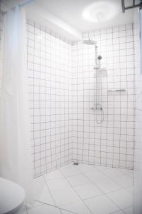 芭堤雅市中心Tali-Yailai Hostel的带淋浴的浴室和白色瓷砖墙壁