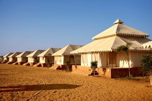 斋沙默尔Bhavya Resort - Luxury Boutique Desert Camp的一块泥土上一排白色的建筑
