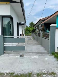 莎阿南Inderaloka Villa 23B Free Parking的建筑物旁有混凝土人行道的房子