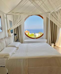 伊斯基亚Agapanto Luxury Accommodation的一间卧室设有一张大床和大窗户