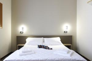 巴勒莫Hotel Roma 62的一张带白色床单和毛巾的床