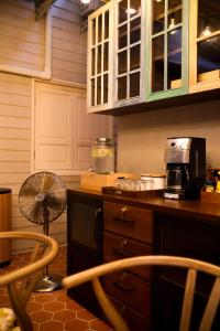 芭堤雅市中心Tali-Yailai Hostel的厨房配有带风扇和微波炉的台面