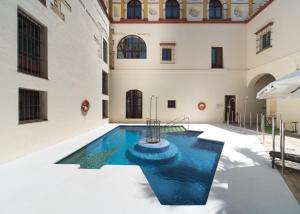桑卢卡尔-德巴拉梅达Hotel Palacio Marqués de Arizón的一座位于大楼中间的室内游泳池