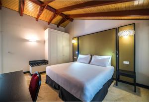 桑卢卡尔-德巴拉梅达Hotel Palacio Marqués de Arizón的卧室配有一张白色大床和一张桌子及椅子