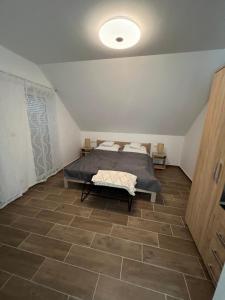 雷夫菲勒普JÁNHÁZ Apartman Révfülöp的卧室配有1张床,铺有瓷砖地板。