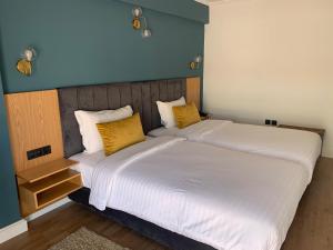 拉巴特拉巴特皇家酒店的卧室配有一张带黄色枕头的大型白色床。