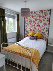 圣奥斯特尔Station House的一间卧室配有一张带花卉壁纸的床