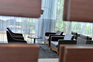 基加利Ubumwe Grande Hotel的带沙发和椅子的等候室和大窗户