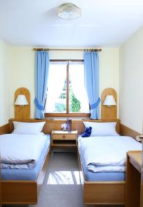 费尔德伯格Ferienwohnungen Haus Schwörer的配有蓝色窗帘的客房内的两张床