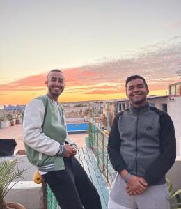索维拉Surf HouseMaroc的两个男人站在阳台的顶上
