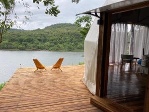 萨尔多斯德莫克纳Reserva La Mision Mocona - Solo Adultos的两把椅子坐在湖边的木甲板上