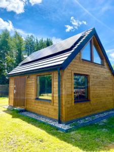 Przystań Sielachowskie的一间拥有太阳能屋顶的小型小木屋