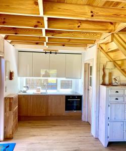 Przystań Sielachowskie的一间带木制天花板的厨房和一间带木制橱柜的大厨房。