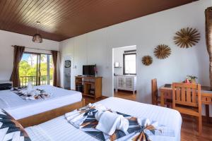 波普托Maya Resort Samui - Family resort-Sha Plus Extra的一间卧室配有两张床、一张桌子和一台电视。