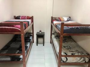 伊瓜苏港Colibrí Hostel的客房设有两张双层床和一张桌子。