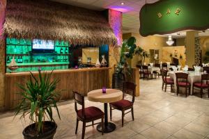 大洋城Grand Hotel Ocean City Oceanfront的一间带桌椅的餐厅和酒吧