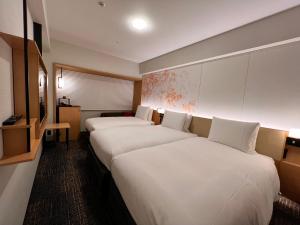 京都Richmond Hotel Premier Kyoto Ekimae的配有白色床单的酒店客房内的两张床