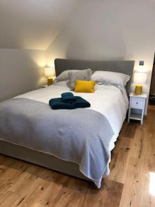 CratfieldThe Hive - beautiful studio with amazing hot tub的一间卧室配有一张带黄色枕头的大床