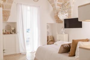 萨维勒特里Apulia Charming Suites - Casa Rossa Suite Perla e Suite Corallo的白色的卧室设有床和大窗户