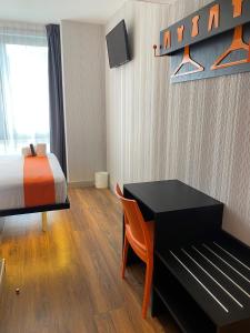 里斯本easyHotel Lisbon的一间卧室配有一张床、一张桌子和一张床