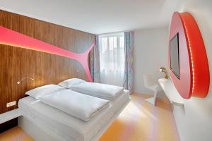 维也纳prizeotel Vienna-City的一间卧室配有一张床,墙上配有电视
