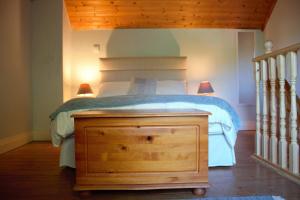 肯梅尔Remarkable Apartment in Kenmare Ireland的一间卧室配有一张带木制梳妆台和两盏灯的床。