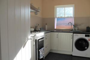 肯梅尔Remarkable Apartment in Kenmare Ireland的厨房配有炉灶和洗衣机。