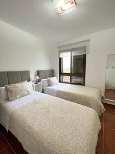 莫卡诺尔La casa de Tenesedra的配有窗户的酒店客房内的两张床
