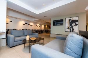 布宜诺斯艾利斯毕斯巴勒莫酒店的客厅配有蓝色的沙发和桌子